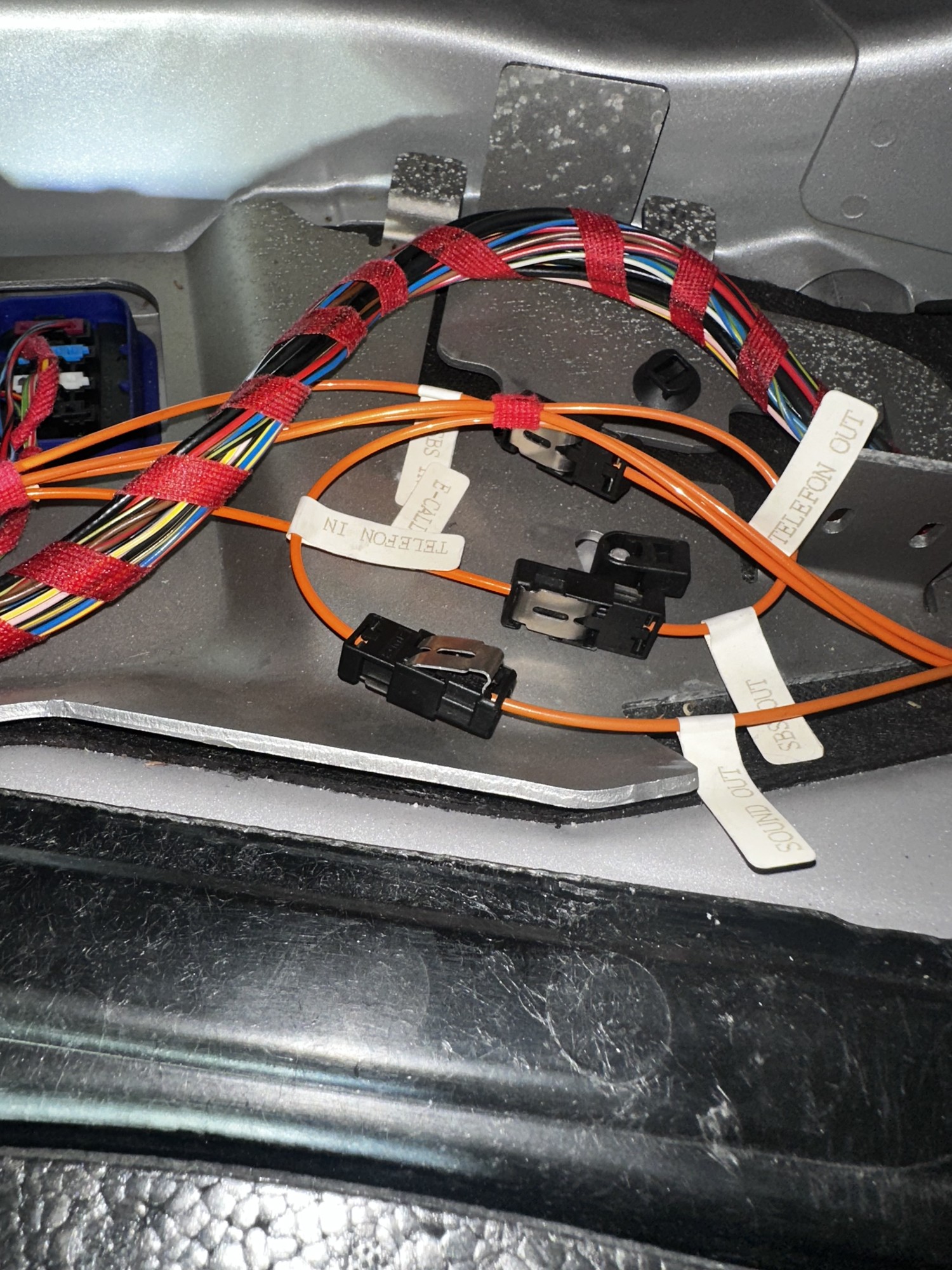 C32 AMG factory fiber-optic connectors and wiring exposed during audio work