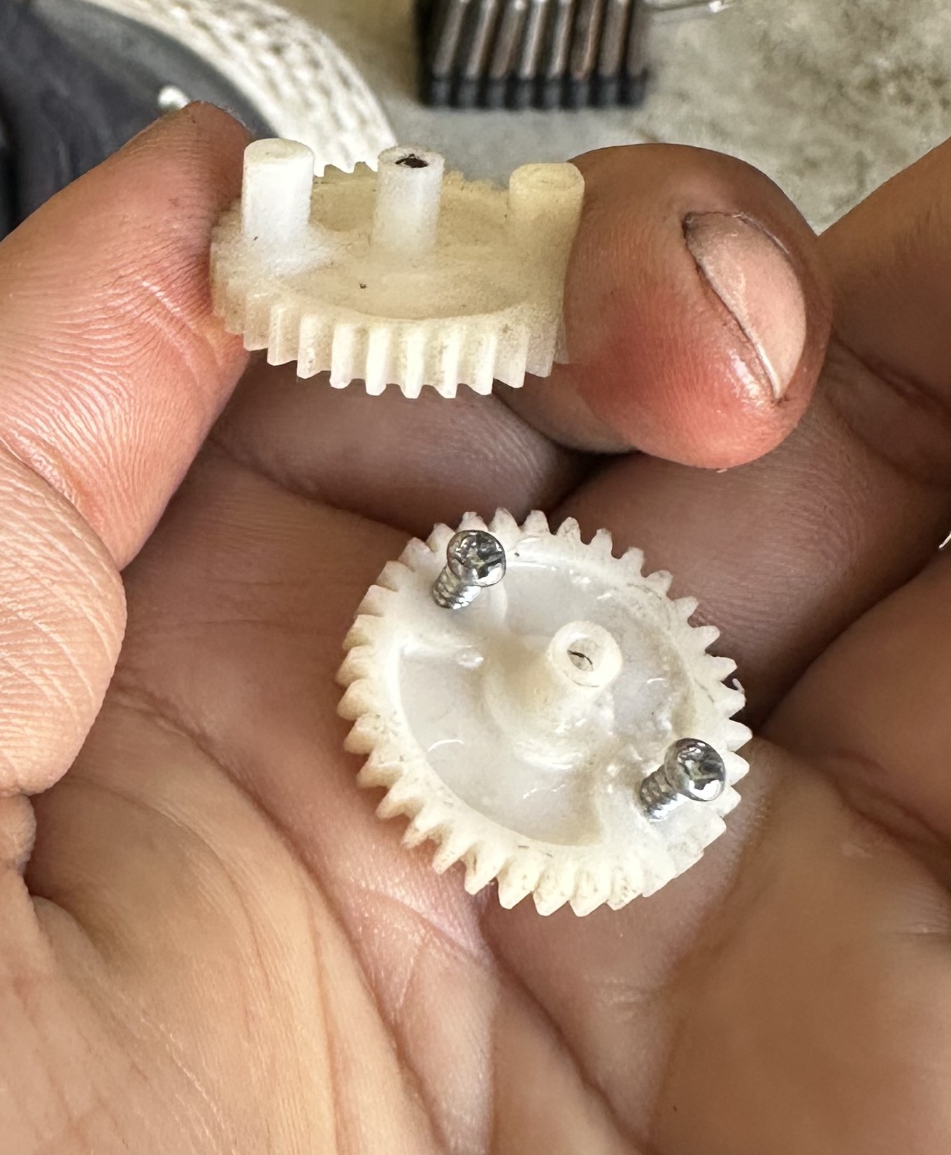 C32 trunk latch gear: molded plastic posts alongside screw replacements, before JB Weld shaping
