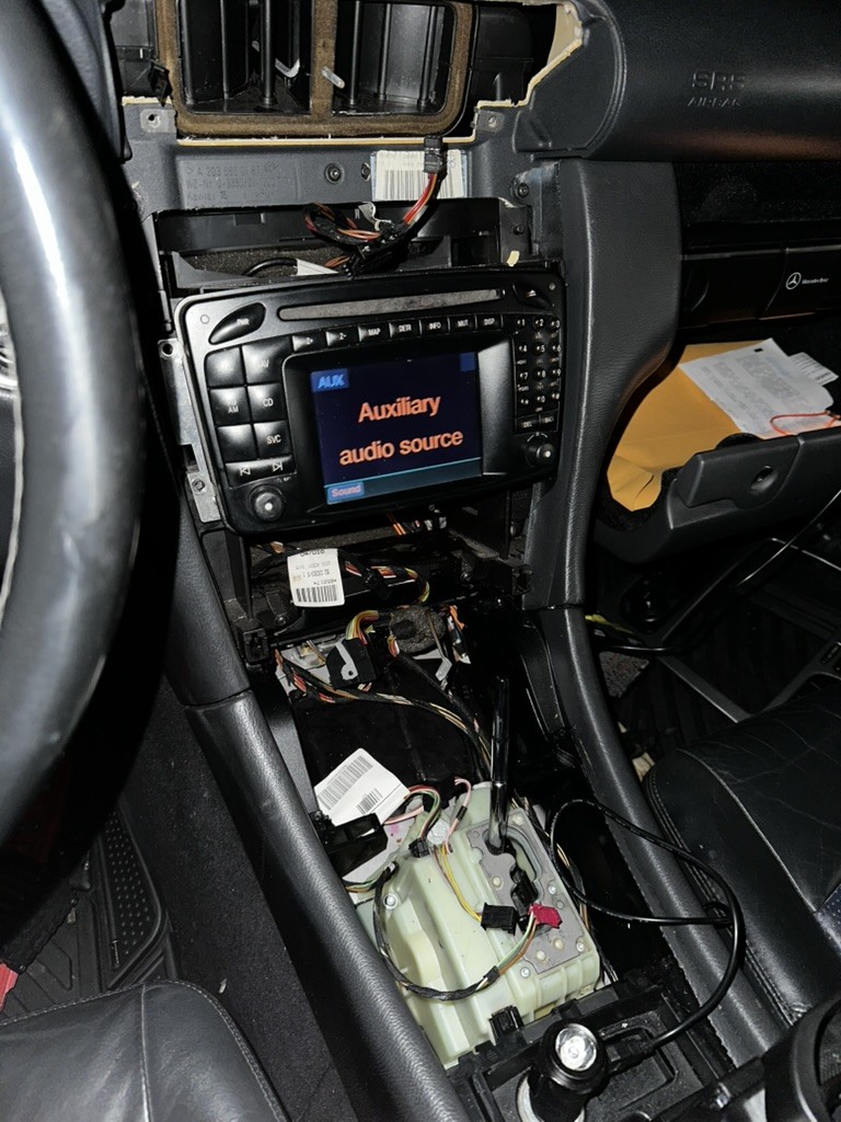 C32 AMG original radio during disassembly; console wiring exposed